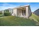 An inviting covered back porch provides a cozy outdoor seating area with a ceiling fan and sliding door entry at 5566 Silver Sun Dr, Apollo Beach, FL 33572