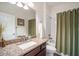 Bathroom features a vanity with granite countertops, toilet, and shower with olive curtain at 5566 Silver Sun Dr, Apollo Beach, FL 33572