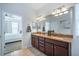 Bathroom with dual sinks, granite countertop, and a large mirror, leading to the bedroom at 5566 Silver Sun Dr, Apollo Beach, FL 33572