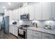 Close-up of modern kitchen with white cabinets, granite counters, and stainless appliances at 5566 Silver Sun Dr, Apollo Beach, FL 33572