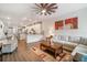 Open concept living room connects to the kitchen with wood floors and natural light at 5566 Silver Sun Dr, Apollo Beach, FL 33572