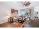 Cozy living room featuring a decorative ceiling fan, wood flooring, and a comfortable sectional sofa at 5566 Silver Sun Dr, Apollo Beach, FL 33572