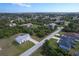 An aerial view of a home in a neighborhood surrounded by lush trees, on a sunny day at 6160 Van Dine St, Englewood, FL 34224