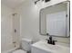 Bathroom with a modern mirror, shower-tub combo, and white vanity at 6160 Van Dine St, Englewood, FL 34224