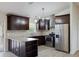 Modern kitchen featuring stainless steel appliances, dark wood cabinets, and stone countertops at 6160 Van Dine St, Englewood, FL 34224