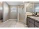 Bright bathroom featuring walk-in shower with glass enclosure and a vanity with sink and mirror at 7911 Floradora Dr, New Port Richey, FL 34654