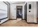 Hallway with black painted trim, view through a doorway with a digital display and light tile floors at 7911 Floradora Dr, New Port Richey, FL 34654