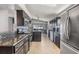 Spacious kitchen featuring stainless steel appliances, granite countertops, dark cabinets and tile backsplash at 7911 Floradora Dr, New Port Richey, FL 34654