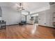 Open-concept living area with wood flooring, fan, and access to the kitchen at 7911 Floradora Dr, New Port Richey, FL 34654