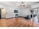 Bright living room featuring wood flooring, fan, and access to the kitchen at 7911 Floradora Dr, New Port Richey, FL 34654