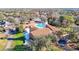 Aerial view of clubhouse and community pool, mature trees, green space and golf course in the distance at 8024 Feather Ct # D, Hudson, FL 34667