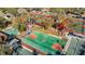 Aerial view of basketball court surrounded by tennis and pickleball courts, mature trees, and a clubhouse at 8024 Feather Ct # D, Hudson, FL 34667