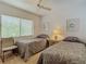 Bedroom featuring twin beds, window and ceiling fan at 8024 Feather Ct # D, Hudson, FL 34667