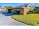 A carport shows multiple parking spaces under a brown awning on a sunny day at 8024 Feather Ct # D, Hudson, FL 34667