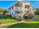 Condo exterior with wooden staircases, a small balcony and green lawn at 8024 Feather Ct # D, Hudson, FL 34667