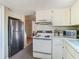 Functional kitchen featuring stainless steel refrigerator and white oven with range at 8024 Feather Ct # D, Hudson, FL 34667