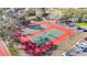 Aerial view of multiple tennis and pickleball courts with mature trees, a clubhouse and parking lot nearby at 8024 Feather Ct # D, Hudson, FL 34667