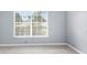 Neutral bedroom with carpet, gray walls, white trim, and large window providing natural light at 8701 Braxton Dr, Hudson, FL 34667