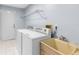 Functional laundry room equipped with a washer, dryer, utility sink, and storage shelving for added convenience at 8701 Braxton Dr, Hudson, FL 34667