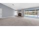 Open living room with a brick fireplace and sliding glass doors to the pool area at 8701 Braxton Dr, Hudson, FL 34667