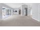Expansive living room with neutral carpet, high ceilings, and a seamless flow to the kitchen at 8701 Braxton Dr, Hudson, FL 34667