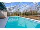 Refreshing screened-in pool with clear blue water and a spacious deck, perfect for outdoor relaxation at 8701 Braxton Dr, Hudson, FL 34667