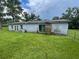 Backyard exterior view of home with lush green yard and exterior door at 9707 Lithia Pinecrest Rd, Lithia, FL 33547
