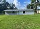 Single-story home with a gray exterior, green lawn, and small front windows at 9707 Lithia Pinecrest Rd, Lithia, FL 33547