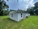 Back exterior view of home with lush green yard and covered patio at 9707 Lithia Pinecrest Rd, Lithia, FL 33547