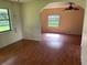 An open living room featuring wood-look floors and multiple windows for natural light at 9707 Lithia Pinecrest Rd, Lithia, FL 33547