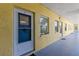 Inviting condo exterior with a well-lit hallway and yellow facade at 9895 1St E St # 5, Treasure Island, FL 33706