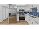 Modern kitchen with white cabinets, stainless steel appliances, and subway tile backsplash at 9895 1St E St # 5, Treasure Island, FL 33706