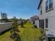 This backyard features a green lawn with trees and a white fence at 17308 Holly Well Ave, Wimauma, FL 33598