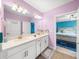 Bathroom featuring a double vanity with a door to the bedroom at 17308 Holly Well Ave, Wimauma, FL 33598