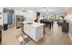 Open-concept kitchen island with white cabinets, gold hardware, and seamless flow to the dining area at 17308 Holly Well Ave, Wimauma, FL 33598