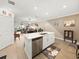 Open kitchen with an island, stainless steel dishwasher, and view to an outdoor patio at 17308 Holly Well Ave, Wimauma, FL 33598