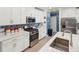 Bright kitchen features white cabinets, stainless steel appliances, and stylish backsplash at 17308 Holly Well Ave, Wimauma, FL 33598