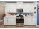 Modern kitchen featuring stainless steel appliances, white cabinets, and stylish backsplash at 17308 Holly Well Ave, Wimauma, FL 33598