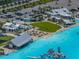 Aerial view of a large lagoon with beach, lounge chairs, playground, and clear blue water at 17308 Holly Well Ave, Wimauma, FL 33598