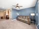 Living room with blue walls, ceiling fan, and adjacent bathroom at 17308 Holly Well Ave, Wimauma, FL 33598