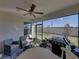 This screened-in patio includes patio seating, a grill, and a view of the backyard at 17308 Holly Well Ave, Wimauma, FL 33598