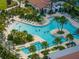 Aerial view of a resort-style pool with palm trees and plenty of lounge chairs at 17308 Holly Well Ave, Wimauma, FL 33598