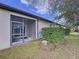 View of the back of the home that has a screened in porch and neatly trimmed bushes at 11212 Port Douglas Dr, New Port Richey, FL 34654