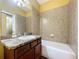 Bathroom with a tiled shower-tub, decorative mirror, sink, and a toilet at 11212 Port Douglas Dr, New Port Richey, FL 34654