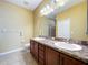 Bathroom featuring double sinks with granite countertops and a large mirror at 11212 Port Douglas Dr, New Port Richey, FL 34654