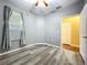 Bedroom featuring light gray walls, a ceiling fan, and a bright window with blinds and curtains at 11212 Port Douglas Dr, New Port Richey, FL 34654
