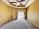 Spacious bedroom with tray ceilings, a modern ceiling fan, and sliding glass doors providing outdoor access at 11212 Port Douglas Dr, New Port Richey, FL 34654