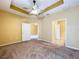 Spacious carpeted bedroom with a ceiling fan and access to a bathroom and closet at 11212 Port Douglas Dr, New Port Richey, FL 34654