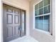 Close up of front door featuring side window, stylish hardware, and beige exterior at 11212 Port Douglas Dr, New Port Richey, FL 34654