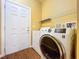 Laundry room with washer, dryer, storage shelves, and a white exterior door at 11212 Port Douglas Dr, New Port Richey, FL 34654